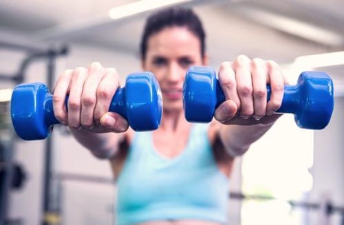 Mulher fazendo exercícios com halteres