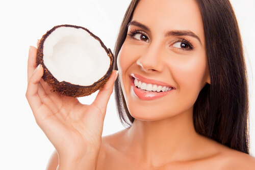 Mulher que usa óleo de coco nos dentes