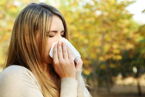 Mulher espirrando com alergia sazonal