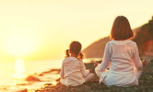 Mãe e filha praticando ioga