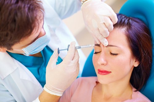Médico aplicando toxina botulínica