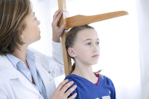 Doutora verificando altura de criança com síndrome de Turner