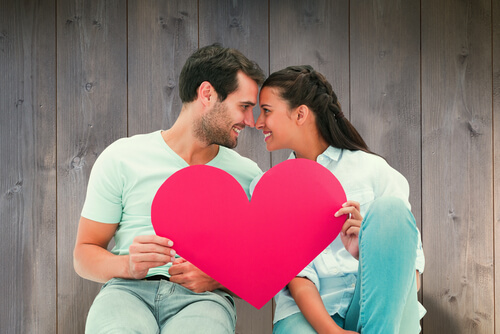 Casal segurando coração vermelho