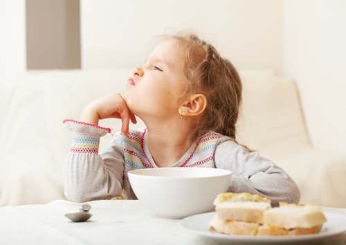 Menina com síndrome da alimentação seletiva que não quer o café da manhã