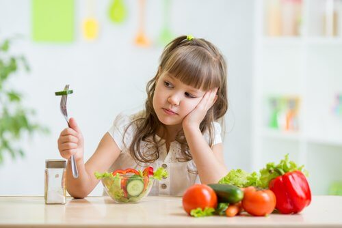 Menina com síndrome da alimentação seletiva que não gosta de vegetais