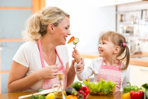 Mãe ensinando sua filha a se alimentar bem