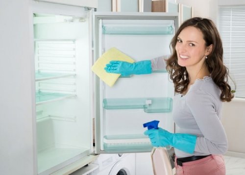 Mulher limpando geladeira