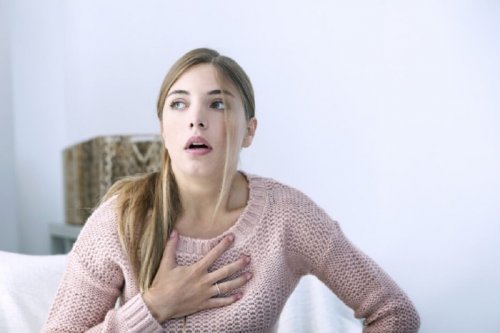 Mulher sentindo sintomas de infarto