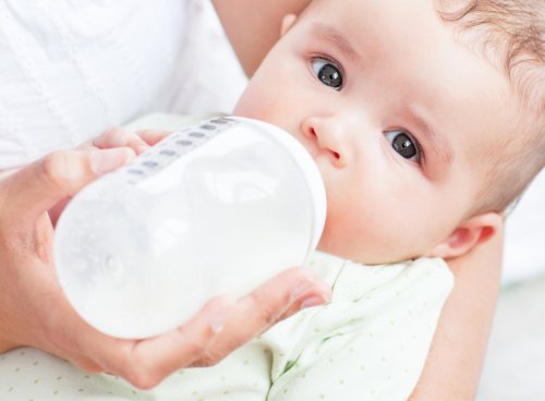 Bebê tomando leite na mamadeira