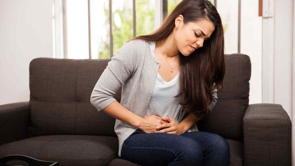 Mulher com dores no estômago