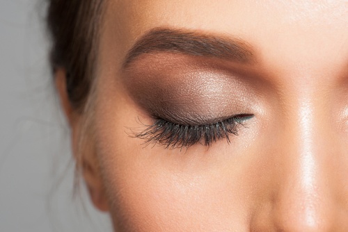 Mulher com os olhos fechados e maquiados