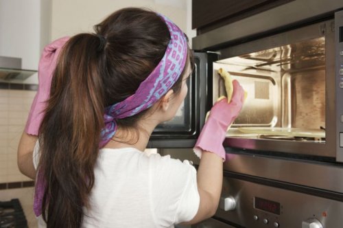 Mulher limpando micro-ondas