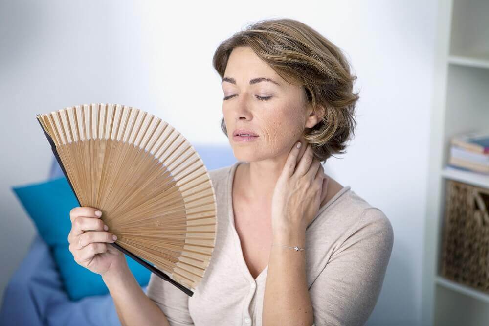 Mulher sentindo calores da menopausa