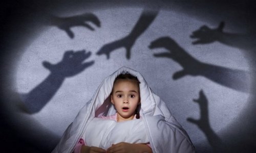 Criança com medo das sombras no escuro