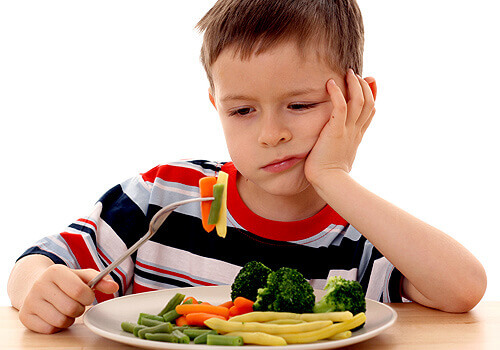 Criança brincando com os vegetais para não comê-los