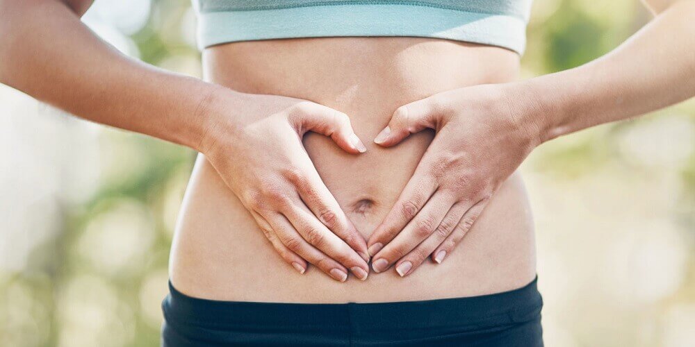 Digestão, mulher com as mãos na barriga