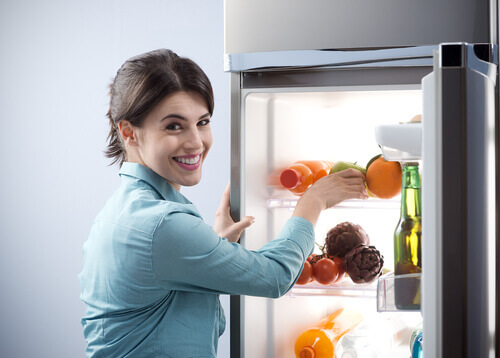 Mulher organizando a geladeira