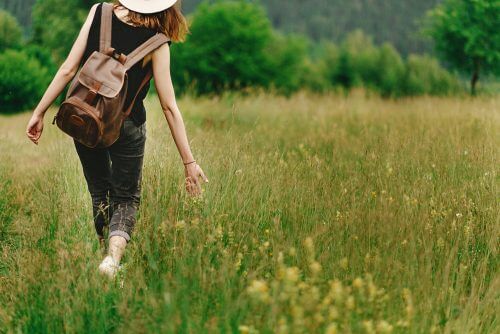 Mulher caminhando no campo, na natureza