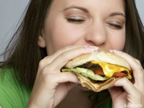Mulher comendo um hambúrguer