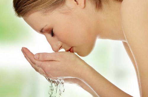 Mulher lavando o rosto