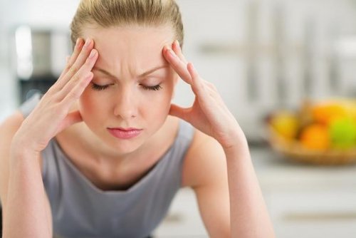 Mulher com dor de cabeça por causa do refluxo gastroesofágico