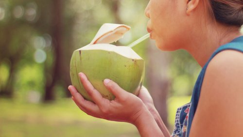 Mulher tomando água de coco