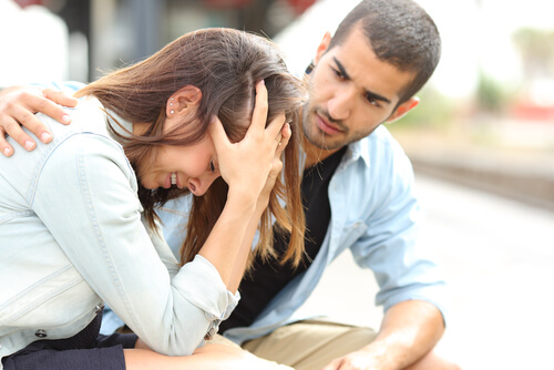Mulher chorando e homem apoiando-a ao seu lado