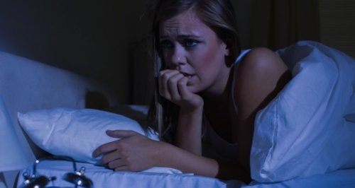 Mulher com ataque de pânico deitada na cama