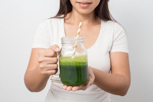 Mulher segurando suco de pepino