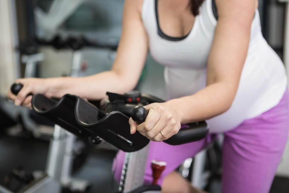 Mulher fazendo bicicleta na academia