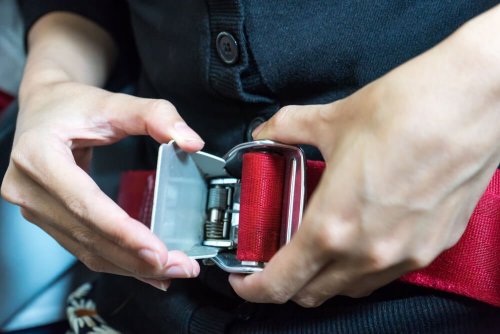 Pessoa colocando cinto de segurança no avião