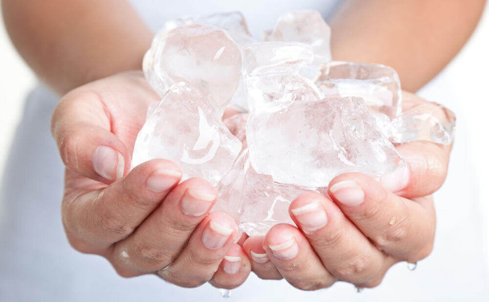 Mãos segurando pedras de gelo