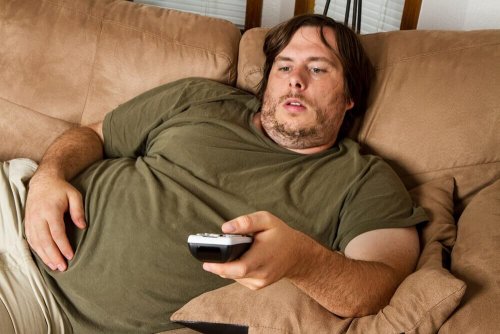 Homem obeso sentado no sofá