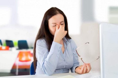 Mulher com visão embaçada no trabalho