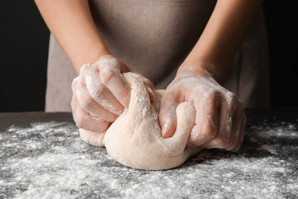 Mulher sovando massa de pão