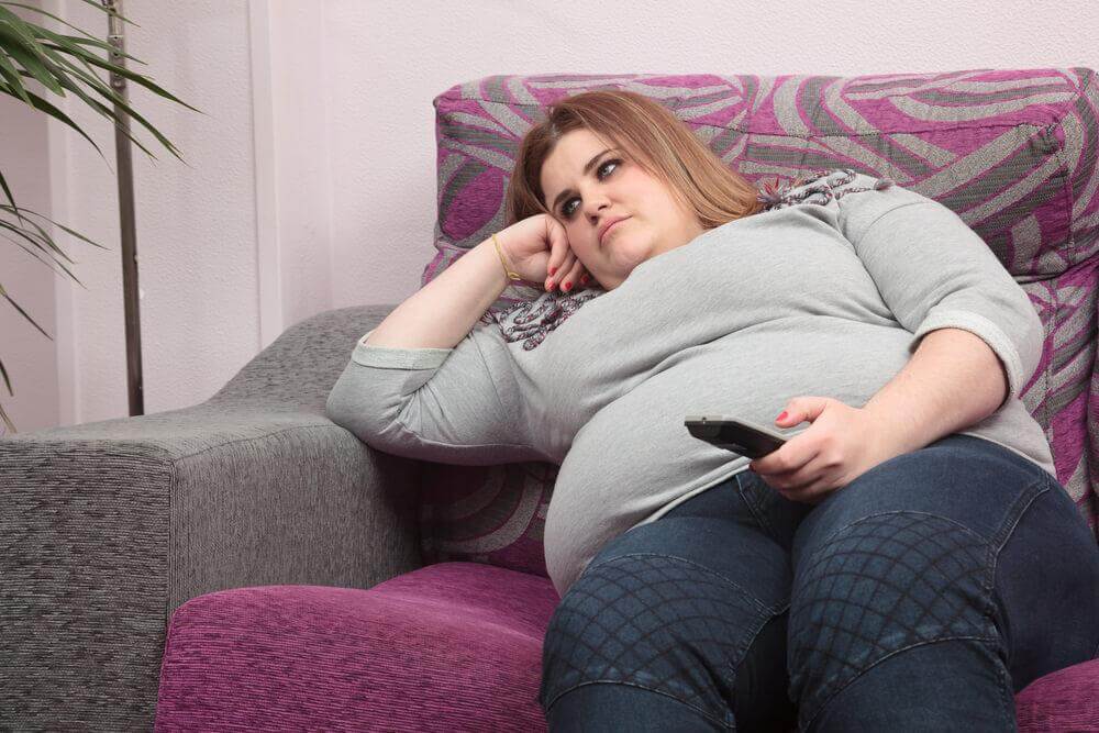 Mulher obesa sentada no sofá