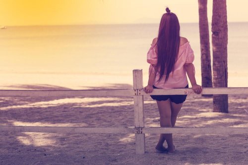 Mulher sozinha olhando o entardecer