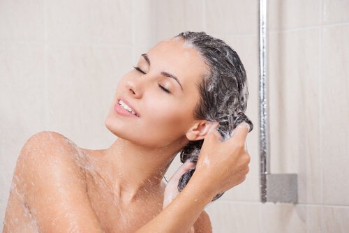 Mulher lavando cabelo longo e saudável