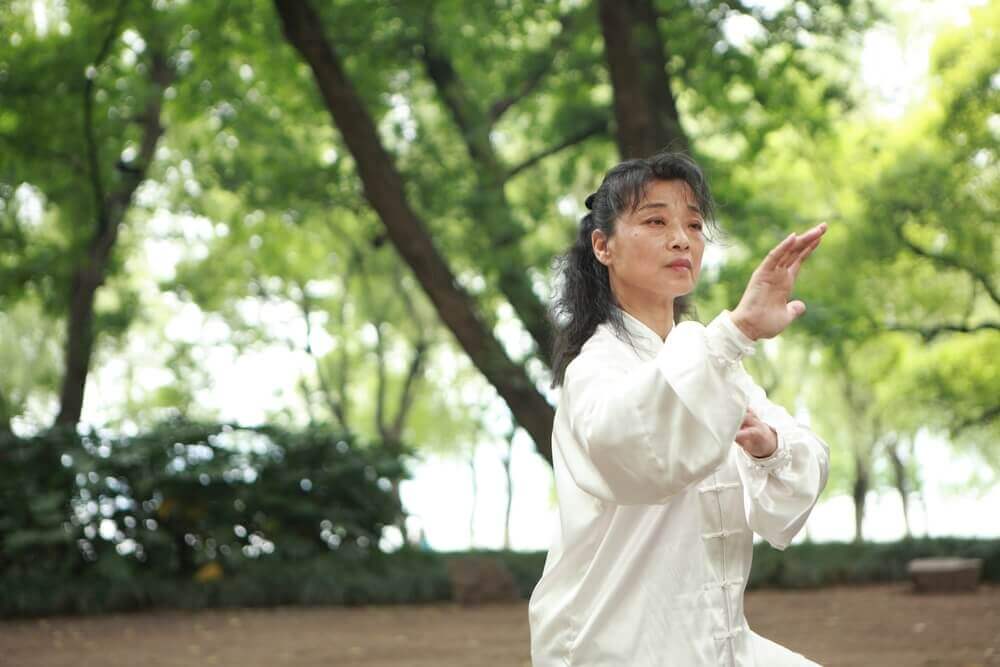 Mulher praticando tai chi no parque