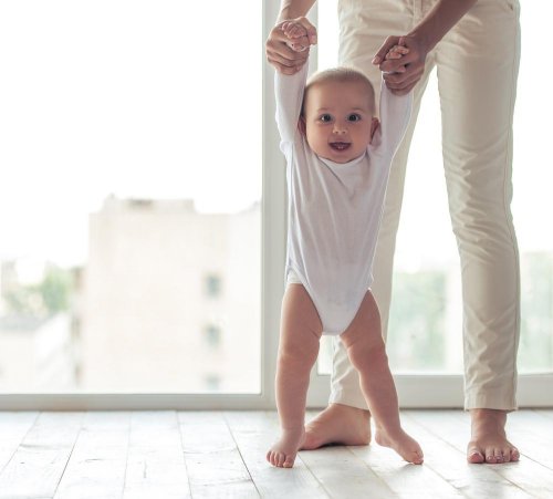 Pessoa ajudando bebê a andar