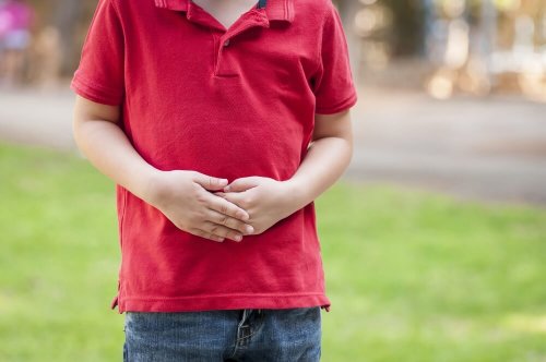 Criança com as mãos sobre a barriga