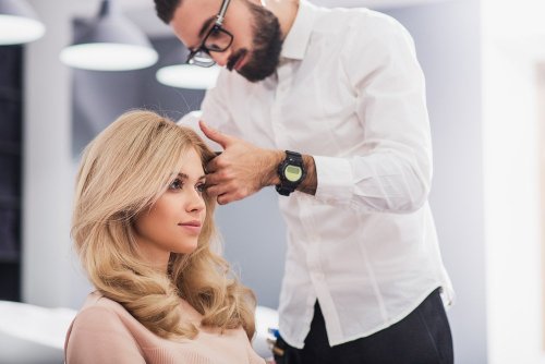 Cabeleireiro cortando cabelo de mulher loira