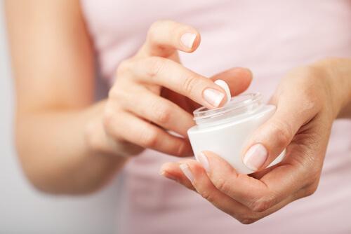 Mulher com pote de creme antirrugas