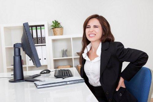 Mulher com dor nas costas no trabalho