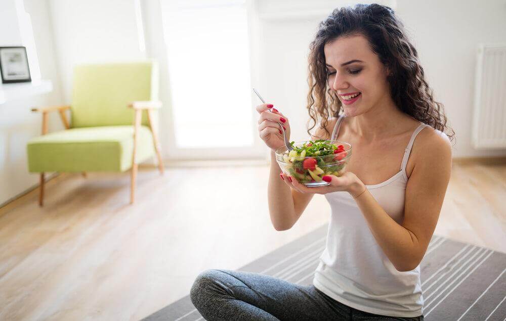 Mulher comendo salada