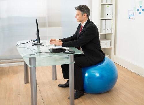 Homem trabalhando sentado em bola