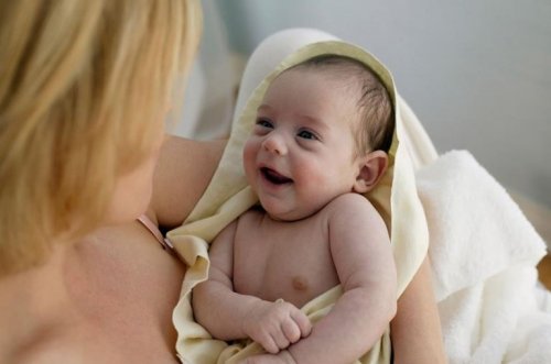 Mãe aconchegando seu bebê após o banho