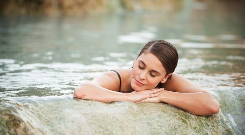 Mulher em cachoeira com águas termais