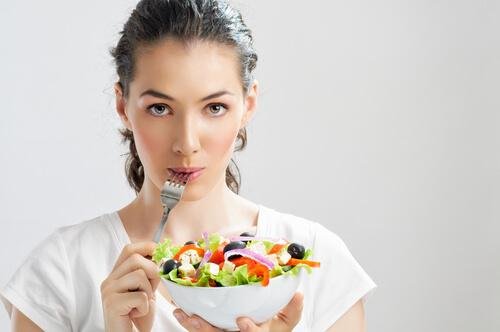 Mulher comendo salada
