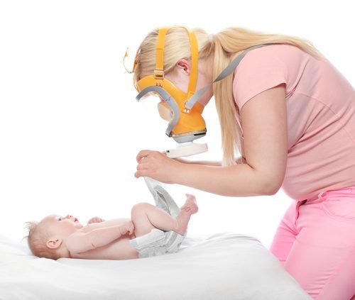 Mãe trocando fralda de bebê com diarreia infantil